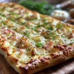 Detailaufnahme eines Flammkuchens, der mit frischem Spargel und Parmesan dekoriert ist.
