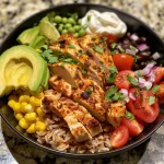 Bunte Chicken Burrito Bowl mit Hühnchen, Bohnen und frischem Gemüse.
