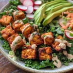 Close-up view of a colorful Tempeh Salad with fresh vegetables and dressing.