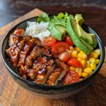 Nahaufnahme eines BBQ-Hühnchen-Bowls mit Reis und frischem Gemüse.