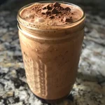 Nahaufnahme eines Mocha-Bananen-Protein-Smoothies in einem Glas.