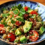 Nahaufnahme eines bunten Quinoa-Salats mit Avocado und frischem Gemüse.