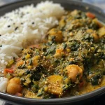 Close-up view of a vibrant Spinat-Curry with Kichererbsen and roten Linsen in a bowl.