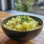 Nahaufnahme von Zitronenreis mit frischen Kräutern in einer Schale.