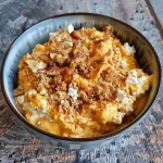 ['A creamy pumpkin cottage cheese bowl topped with granola and nuts.', 'Close-up view of a cottage cheese bowl with pumpkin puree and cinnamon.', 'Side view of a delicious pumpkin cottage cheese dish garnished with whipped cream.', 'A colorful breakfast bowl featuring cottage cheese, pumpkin, and various toppings.']