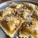 ['Close-up view of creamy pumpkin ravioli with a rich sauce and herbs.', 'Side view of freshly made pumpkin ravioli garnished with Parmesan and nuts.', 'Creamy pumpkin ravioli on a plate, showcasing a velvety sauce and vibrant colors.', 'Detailed shot of ravioli with pumpkin filling, topped with herbs and nuts.']