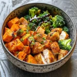 ['Close-up of a crispy chicken and roasted sweet potato bowl, showing tender chicken and vibrant vegetables.', 'Side view of a delicious bowl featuring crispy chicken, sweet potato cubes, and broccoli florets.', 'An appetizing bowl with juicy crispy chicken, cubed sweet potatoes, and a drizzle of balsamic glaze.', 'A colorful meal showcasing roasted sweet potatoes, chicken breast, and broccoli topped with Greek yogurt.']