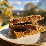 ['Close-up view of healthy pumpkin oat cookies with chocolate chips on a wooden surface.', 'A side view of baked pumpkin oat cookies, showcasing their texture and color, on a light background.', 'Delicious pumpkin oat cookies displayed with a few chocolate chips scattered around for decoration.', 'A detailed photo of healthy pumpkin oat cookies arranged on a plate, highlighting their moist appearance.']