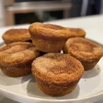 ['Close-up view of flaky gluten-free pumpkin biscuits on a wooden surface.', 'Side angle of delicious gluten-free pumpkin biscuits with a golden-brown crust.', 'Juicy pumpkin biscuits displayed on a plate, showcasing their flaky texture.', 'Freshly baked pumpkin biscuits with a soft interior and crispy exterior captured in detail.']
