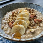 ['Close-up view of a bowl of oatmeal topped with almond butter and fruits.', 'Creamy oatmeal with a drizzle of almond butter, garnished with nuts and fruit.', 'A side perspective of almond butter oatmeal in a rustic bowl, showcasing its texture.', 'Delicious oatmeal dish with almond butter and colorful toppings, shot from the side.']