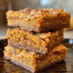 ['Close-up shot of pumpkin maple blondies with a golden brown texture.', 'Side view of rich blondies drizzled with maple syrup, showcasing their moist interior.', 'Delicious pumpkin blondies with a hint of spice, presented on a rustic wooden table.', 'Juicy blondies made with pumpkin puree, displaying their soft texture and warm color.']