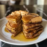 ['Close-up shot of fluffy pumpkin protein pancakes stacked on a plate.', 'Side view of golden brown pumpkin pancakes with syrup drizzling down.', 'Delicious pumpkin protein pancakes topped with chocolate chips and maple syrup.', 'Thick and fluffy pumpkin pancakes served on a wooden table.']