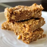 ['Close-up view of a pumpkin spice protein bar with a textured surface.', 'Side view of a gluten-free protein bar showcasing its layered ingredients.', 'A juicy pumpkin spice protein bar with white chocolate chips on a wooden surface.', 'Detailed shot of a healthy protein bar featuring pumpkin puree and oats.']