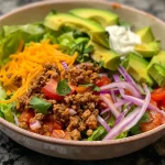 ['Close-up of a colorful Turkey Taco Salad with vibrant vegetables and toppings.', 'Side view of a hearty Turkey Taco Salad featuring ground turkey and fresh ingredients.', 'Detailed view of a Turkey Taco Salad showcasing layers of lettuce, cheese, and avocado.', 'Juicy Turkey Taco Salad arranged with toppings in a bowl, highlighting the fresh ingredients.']