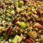 ['Close-up of a vibrant wild rice pilaf with autumn vegetables.', 'Side view of wild rice pilaf featuring chunks of acorn squash and cranberries.', 'Rich wild rice pilaf garnished with chopped parsley and orange zest.', 'Plate of wild rice pilaf showcasing diced apple, pecans, and thyme.']