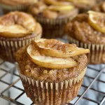 ['Close-up side view of delicious cinnamon pear muffins topped with a golden crust.', 'Juicy Bosc pear muffins with a sprinkle of cinnamon, showcasing a moist texture.', 'A side perspective of fresh cinnamon pear muffins with visible pear chunks peeking through.', 'Soft, fluffy muffins featuring bits of pear and a hint of cinnamon on the surface.']