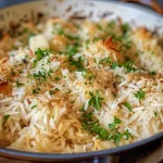 Close-up of a creamy rice pilaf garnished with parsley.
