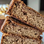 Close-up side view of a moist ginger molasses brunch cake with a light dusting of powdered sugar.