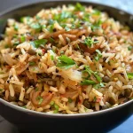 Close-up view of Mujadara, showcasing lentils and rice topped with caramelized onions.