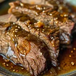 Close-up view of a juicy orange ginger pot roast with garnishes.