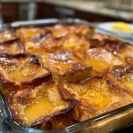 Close-up side view of a juicy Traeger smoked French toast casserole topped with cherries.