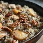 Close-up shot of wild rice dish with chopped pecans and apple.