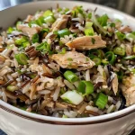 Close-up view of a bowl of Wild Rice Pilaf, showcasing textures of rice and scallions.